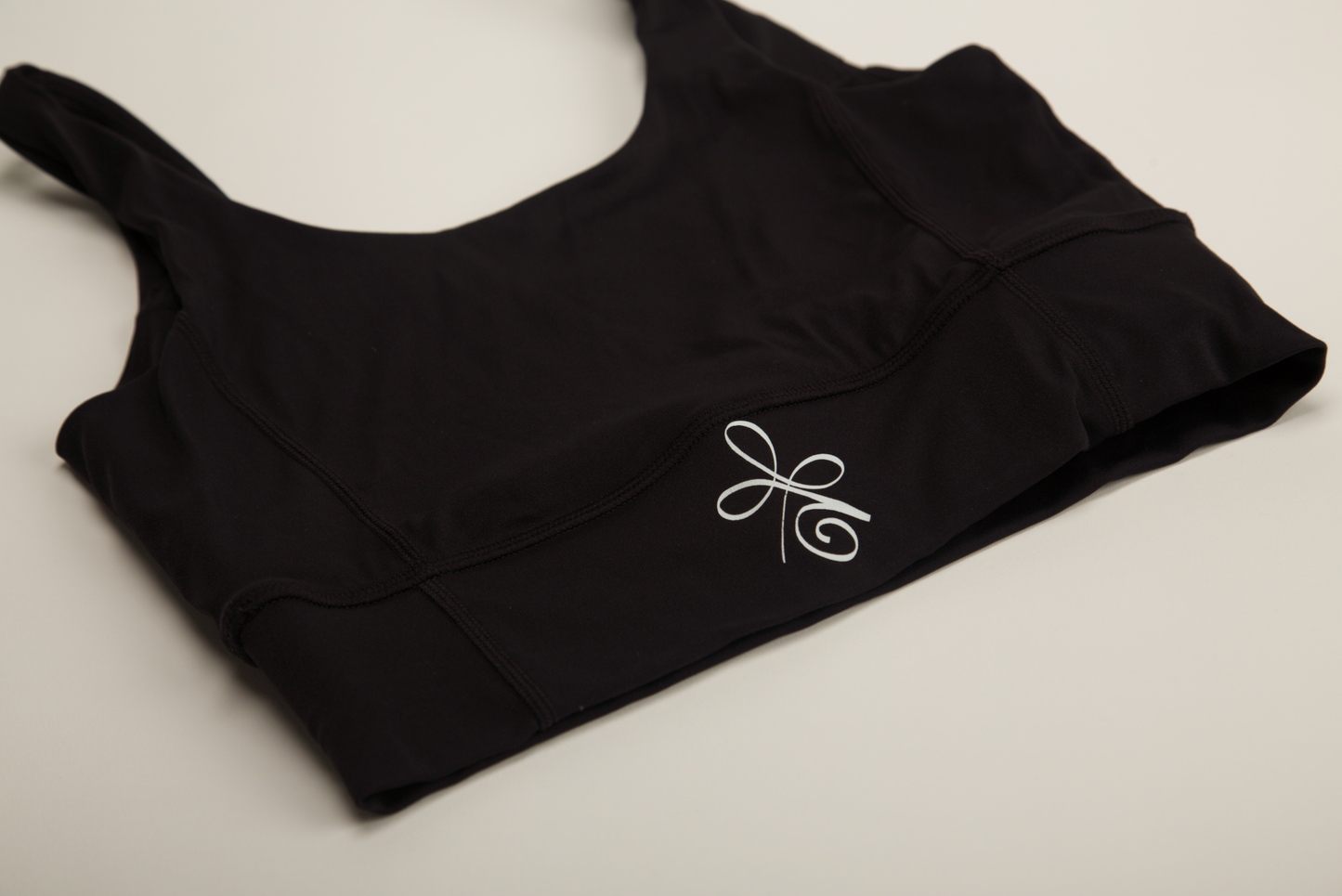 Empower your workout routine with our figure-flattering black sports bra, crafted for maximum support and style with a bold logo accent.