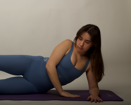 Capture attention and inspire action with our trendy dusty blue sports bra, modeled by a stylish woman with brown hair.