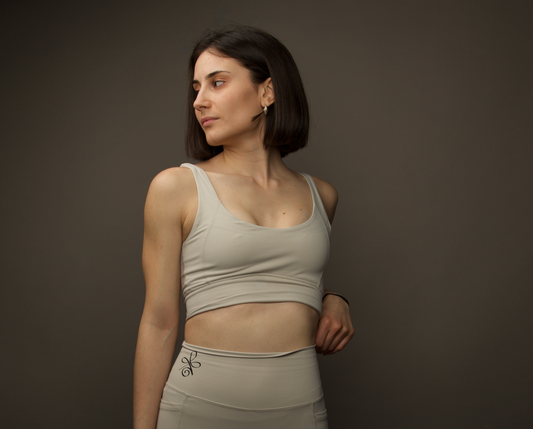 Elevate your gym attire with our sandy beige sports bra, featuring a figure-enhancing design and versatile removable pads.